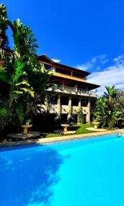 ein Resort mit einem Swimmingpool vor einem Gebäude in der Unterkunft Pousada Canto das Corujas in São Roque