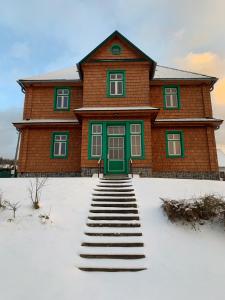 una casa con una puerta verde en la nieve en Chata Klášter, en Hraběšice