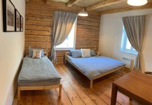 1 dormitorio con 2 camas en una habitación con suelo de madera en Chata Klášter, en Hraběšice