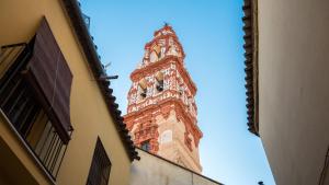 a tall tower with a clock on top of a building at Apartamento Civitas in Écija