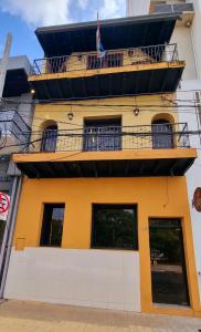 a building with a balcony on top of it at Circo Hostel in Asunción