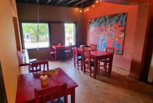 a restaurant with tables and chairs and a painting on the wall at Circo Hostel in Asuncion