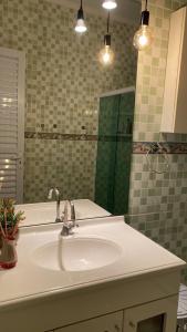 W łazience znajduje się umywalka i lustro. w obiekcie Casa Zona Sul w mieście Rio de Janeiro