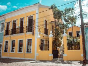 a yellow house with a tree in front of it at Embaixada preta in Cachoeira