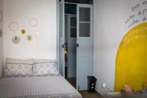 1 dormitorio con cama y pared amarilla en Casa Pretahub, en Cachoeira