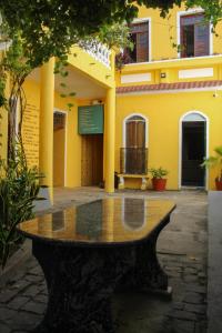 a stone table in front of a yellow building at Casa Pretahub in Cachoeira