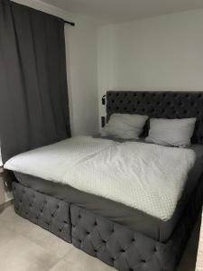 a large bed with a black headboard in a bedroom at All In in Oberhausen