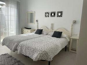una camera da letto con un letto con un piumone bianco e nero di Lovely Home Casa Tamaide - Costa del Silencio - a Costa Del Silencio