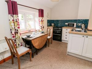 a kitchen with a table and chairs and a sink at Peniarth in Pen-y-bont-fawr