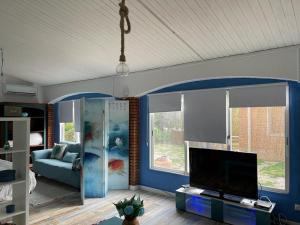 ein Wohnzimmer mit einem TV und einem Sofa in der Unterkunft Raconet Azul - Circuito Cataluña in Vallromanas