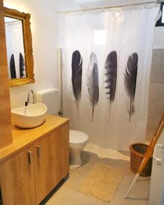 a bathroom with a shower curtain with feathers on it at My Place Apartmani in Boljevac