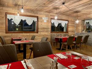 un ristorante con pareti in legno, tavoli e sedie di Hotel Gembro a Chiesa in Valmalenco