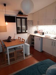 a kitchen with a table and chairs and a kitchen with white cabinets at Nadadouro Eco-country-cottage in Nadadouro
