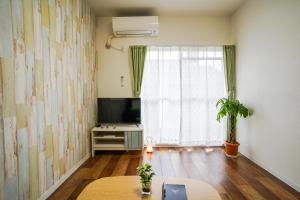 a living room with a table and a tv and a window at stay's サンジョイフル 304号 名古屋 民泊 駅近 in Nagoya