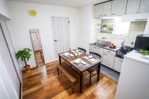 a kitchen with a wooden table and a kitchen with a refrigerator at stay's サンジョイフル 304号 名古屋 民泊 駅近 in Nagoya