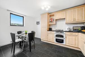 uma cozinha com armários de madeira e uma mesa com cadeiras em Riverside Lodge - Grampian Lettings Ltd em Aberdeen