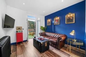 a living room with a brown leather couch and blue walls at Roslin Place - Grampian Lettings Ltd in Aberdeen