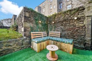 a bench sitting in front of a stone wall at Roslin Place - Grampian Lettings Ltd in Aberdeen