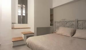 1 dormitorio con cama, ventana y espejo en Estudio con encanto Ubrique wifi, en Ubrique