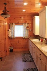 a log cabin bathroom with a sink and a window at A River Runs Through It in Sevierville