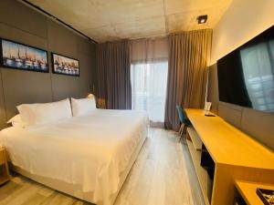 a bedroom with a large white bed and a desk at La Capilla - Punta del Este in Punta del Este