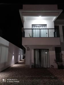 a large white building with a balcony at night at Casa geminada 2 no Mariscal in Bombinhas