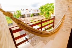 a hammock on the balcony of a house at Casa aconchegante em São Miguel dos Milagres-AL in São Miguel dos Milagres