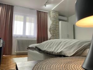 a bedroom with a bed and a stone fireplace at Apartman Bonaca in Niš
