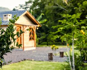 a small wooden dog house in a garden at Chalé Girassol in Praia Grande