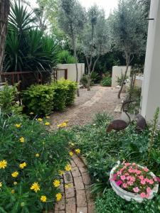a garden with flowers and a walk way at 6 Olives on Third in Johannesburg