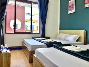 a room with two beds and a window at Toru Homestay in Quy Nhon