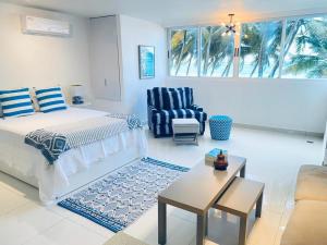 聖胡安的住宿－KASA Las Palmas studio apt for 2 OCEAN VIEW BEACHFRONT CONDO POOL，一间卧室配有一张床、一把椅子和一张桌子