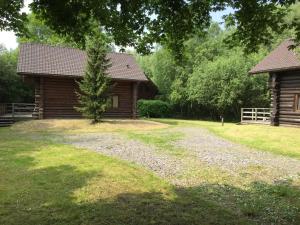 a log cabin with a gravel road next to a house at Charming Chalet with Swimming Pool in Quend in Quend