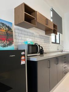 eine Küche mit einer Arbeitsplatte und einer Mikrowelle in der Unterkunft Imperio Professional Suites @ FD Homestay in Alor Setar
