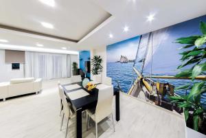 a dining room with a large painting of a boat in the water at Petros in Tsilivi