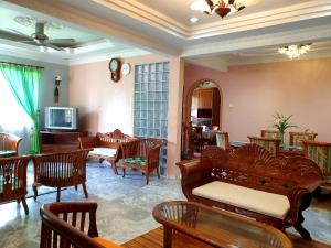 sala de estar con muebles de cuero y TV en Lavender Impian Homestay en Kajang