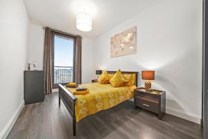 a bedroom with a bed with a yellow bedspread at Maberly Lux - Grampian Lettings Ltd in Aberdeen