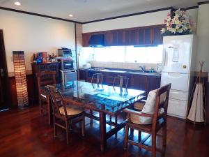 cocina con mesa, sillas y nevera en Villa CocoNatu - KOHAMA - en Kohama