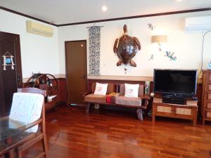 sala de estar con TV y sofá en Villa CocoNatu - KOHAMA - en Kohama