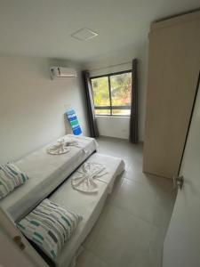 a bedroom with two beds and a window at Apartamento Luxo no coração de Porto 103 in Porto De Galinhas