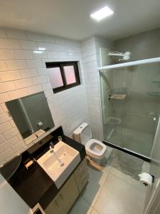 a bathroom with a sink and a shower and a toilet at Apartamento Luxo no coração de Porto 103 in Porto De Galinhas