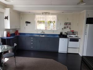a kitchen with blue counter tops and white appliances at Coromandel Tapu - Beachfront Escape in Tapu