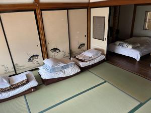 a room with three beds in a room with windows at Yoshimura Kajihara-Tei in Fujikawaguchiko