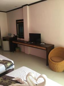 Cette chambre comprend un bureau et un lit avec un miroir. dans l'établissement Grand Thai House Resort, à Lamai