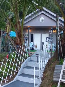 a house with stairs leading to the front door at Sya Cottage in Kuala Pilah