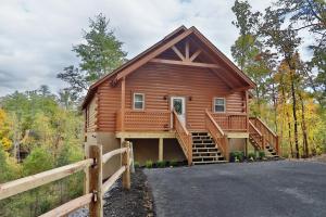 une cabane dans les bois avec une clôture dans l'établissement Deer Pass Lodge, à Pigeon Forge