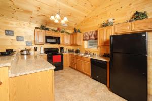 una cucina con armadi in legno e frigorifero nero di Deer Pass Lodge a Pigeon Forge