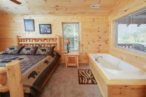 una camera con letto e vasca da bagno di Deer Pass Lodge a Pigeon Forge