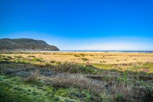 a sandy beach with the ocean in the background at Cozy Seaside Bungalow, Brand New Hot Tub, Fast WiFi & W&D - Walk to the Beach in Seaside
