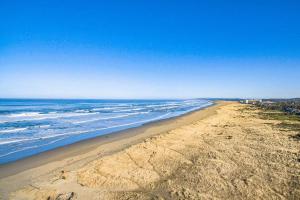 an aerial view of a beach with the ocean at Cozy Seaside Bungalow, Brand New Hot Tub, Fast WiFi & W&D - Walk to the Beach in Seaside +46 photos